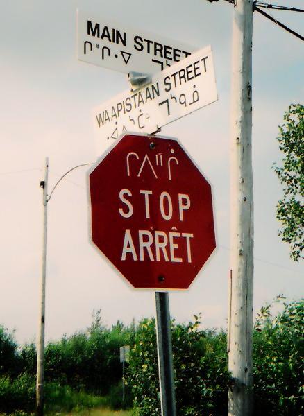 Road sign with text in English, French and Cree 