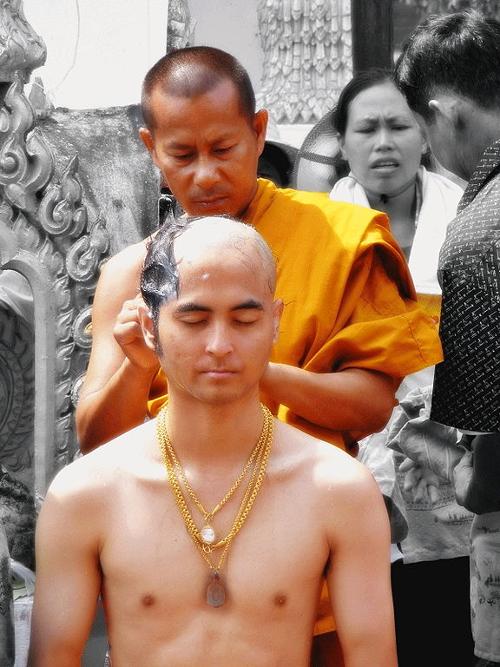 Head of a future priest is shaved in the tradition of therevada Buddhism